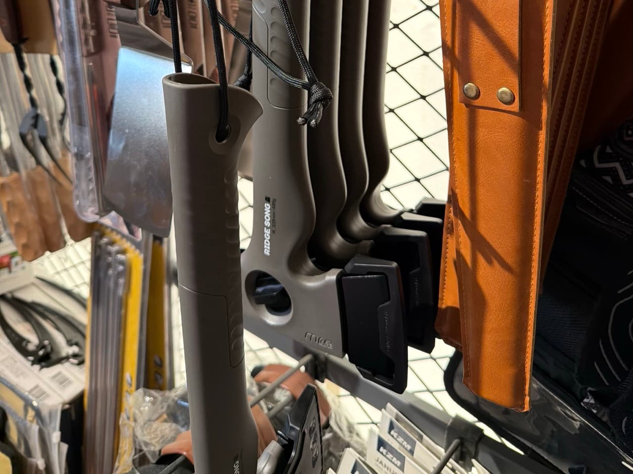 Camping axes hanging on a gear-shop display rack.